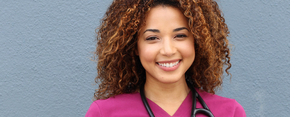 Young female nurse smiling at the camera.